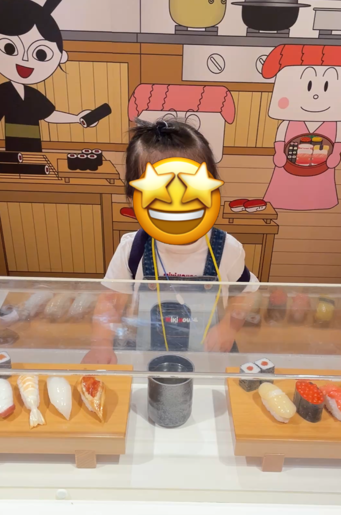 お寿司のコーナーで遊んでいる娘