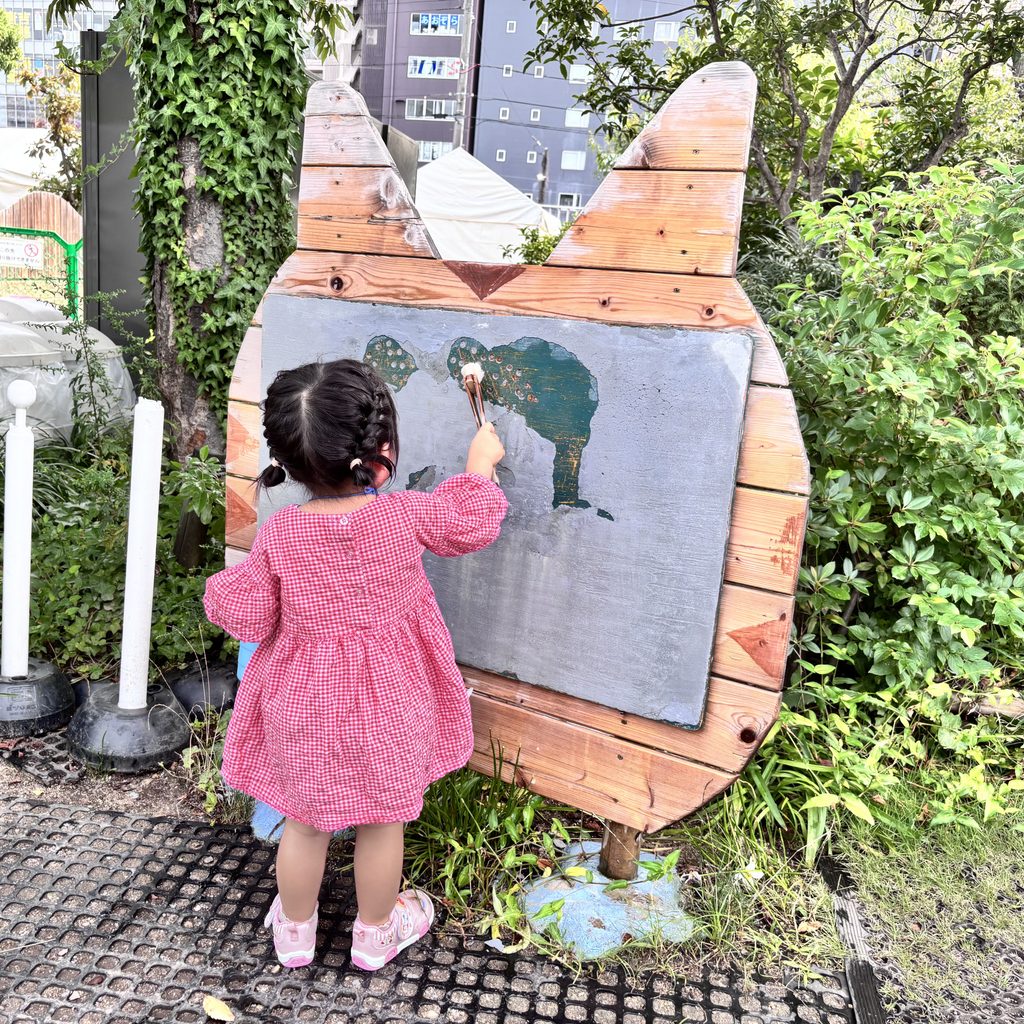 水でおえかきをして遊ぶ娘